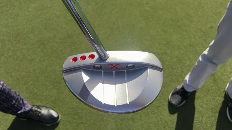 The shaft is perfectly aligned when the red dots disappear from the player's view at address.