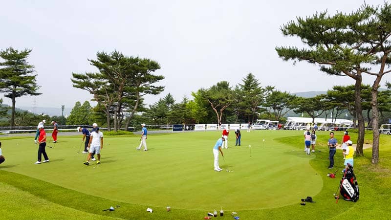 Players on the practice green in Korea.