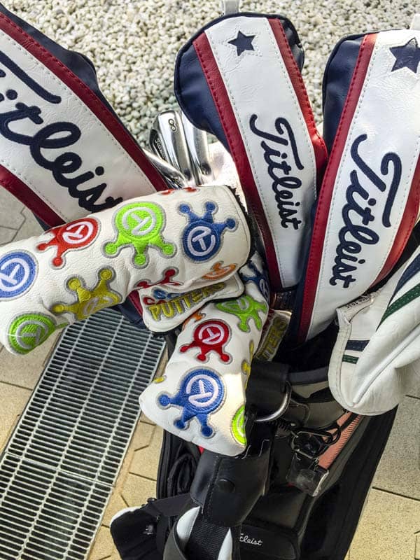 Dancing Crowned Circle T headcovers protecting their Scotty Cameron putters.